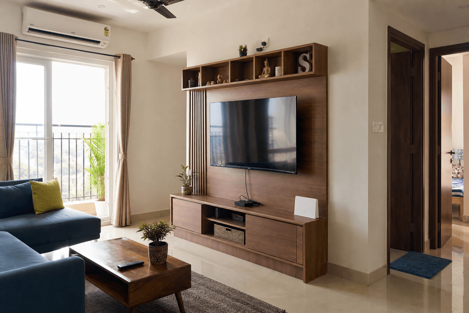 Compact living room with storage console and warm wood TV unit in a 2BHK apartment