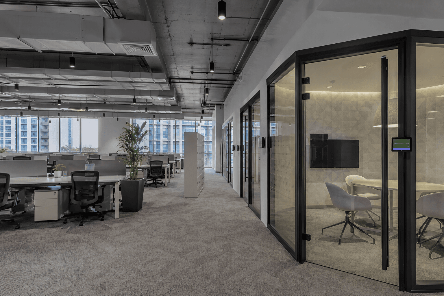 Open-plan office workspace with workstations and meeting pods in Hyderabad
