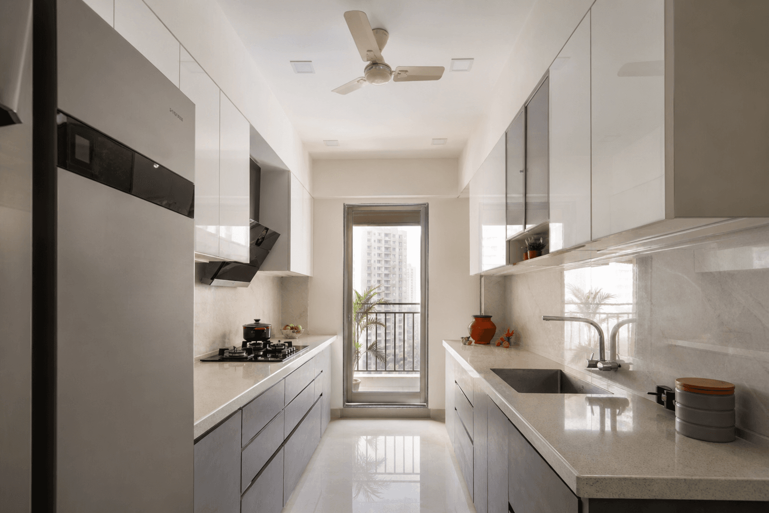 Compact parallel modular kitchen in an Indian apartment with quartz counters and soft-close drawers