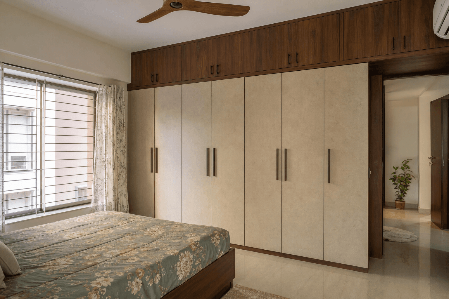 Bedroom wardrobe with loft storage spanning the full wall in an Indian apartment