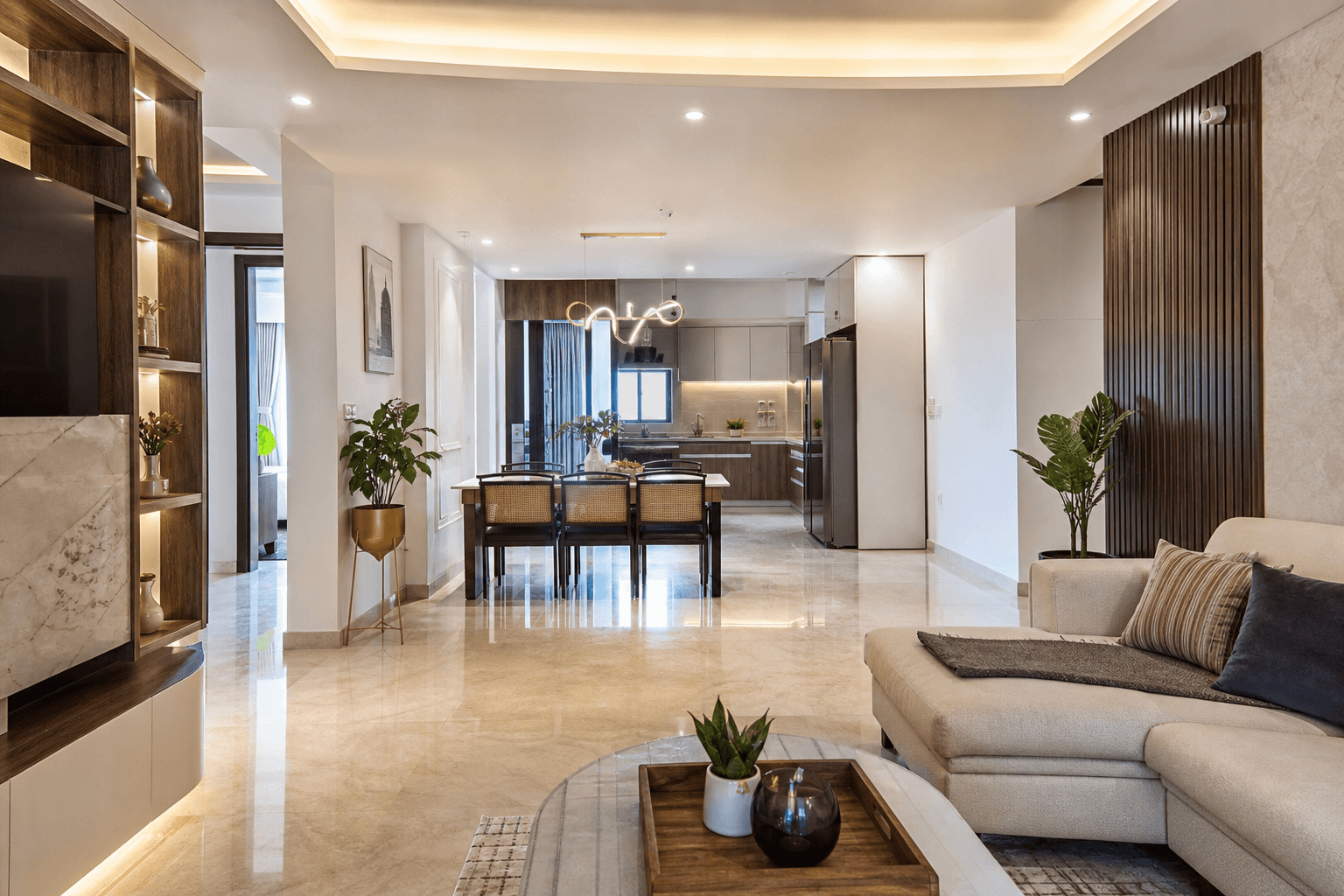 Wide open-plan Indian apartment interior showing connected living, dining and kitchen spaces